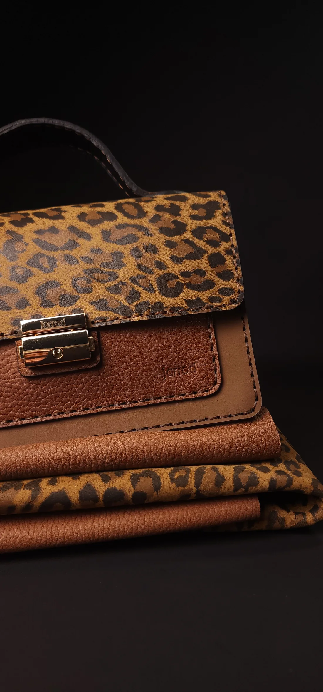 Jarrod leopard-print leather bag resting on folded hides